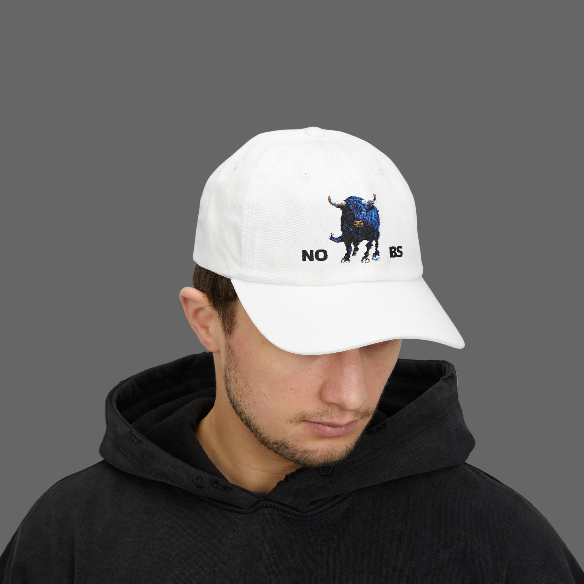 Person wearing a white cap with a bull graphic and text, on a white background