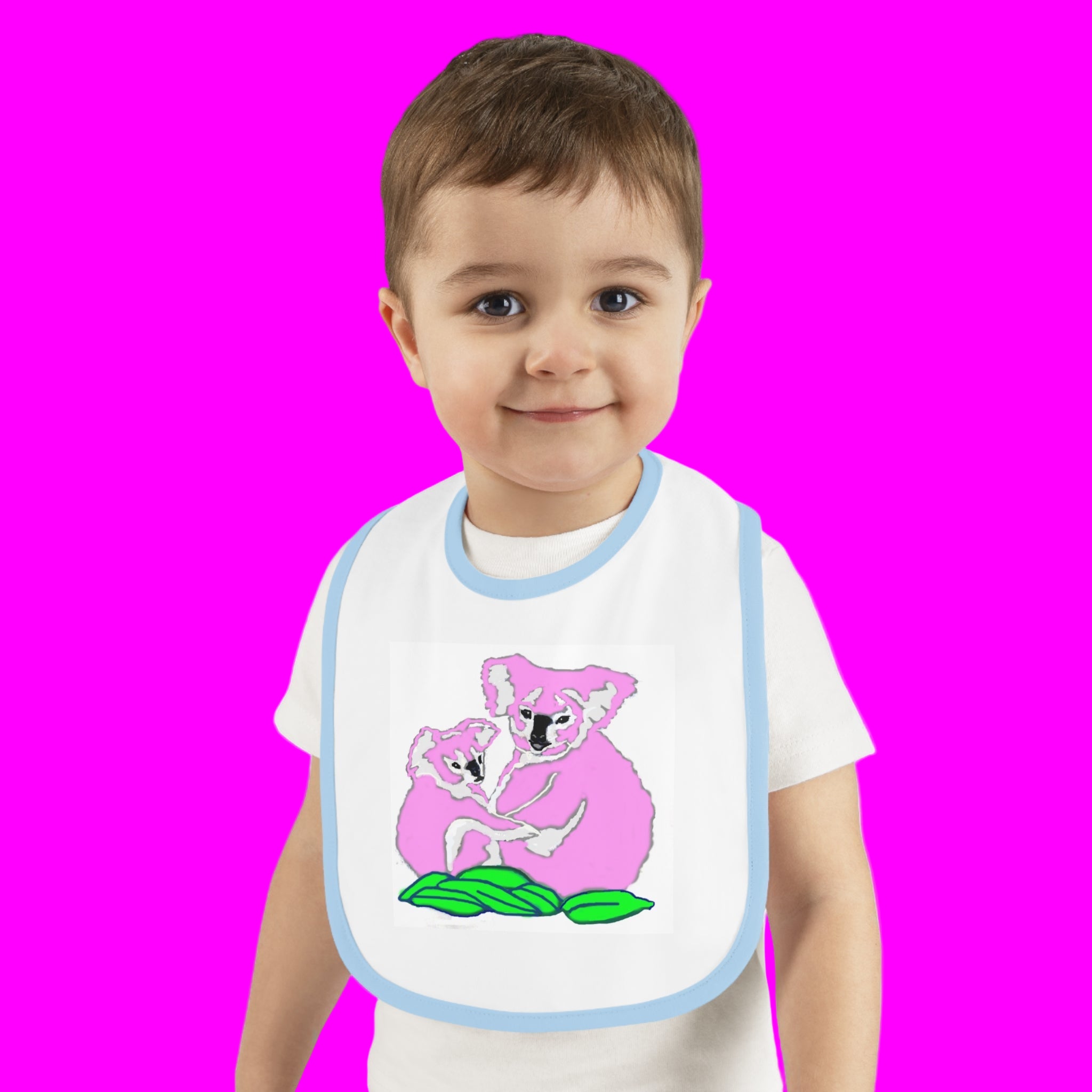 Child wearing a bib with a pink koala design on a white background