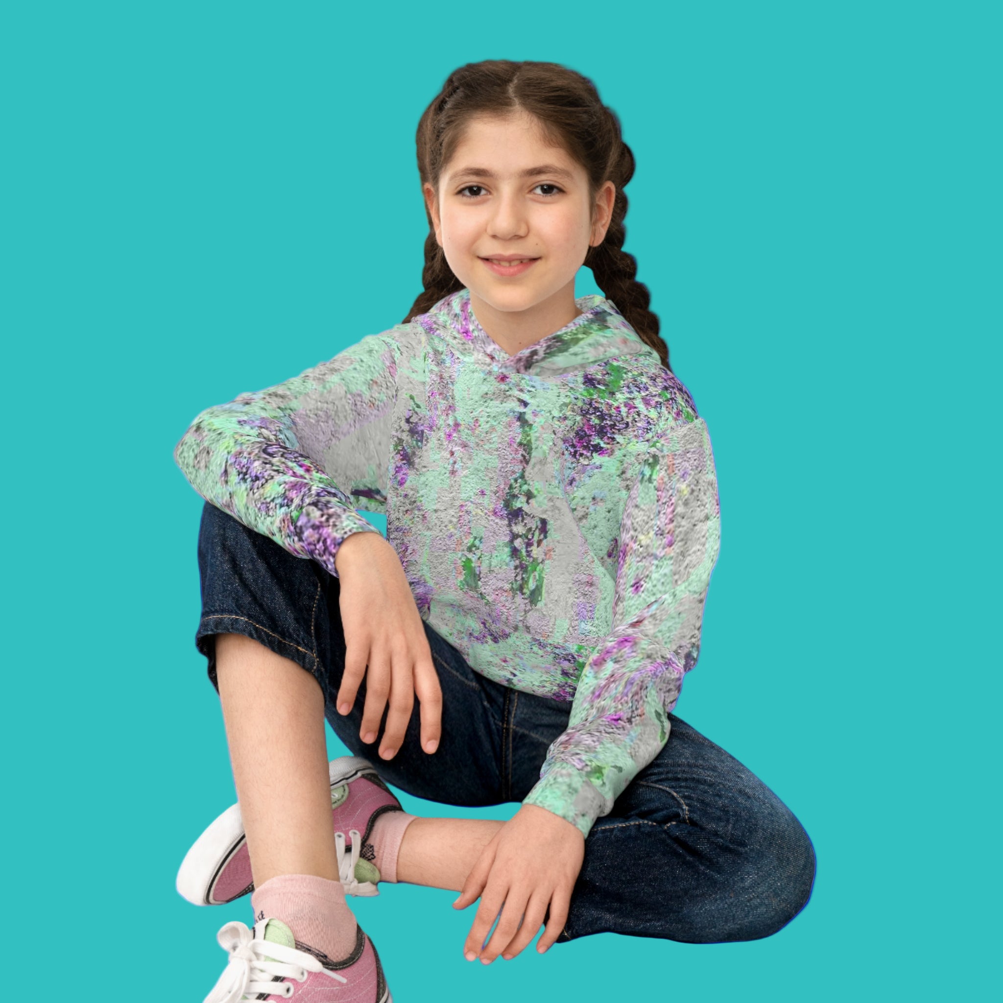 Young girl wearing an abstract art hoodie sitting on the floor