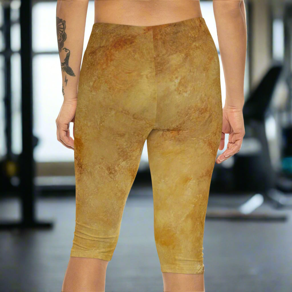 Capri leggings with a textured looking brown abstract pattern on a woman in a gym