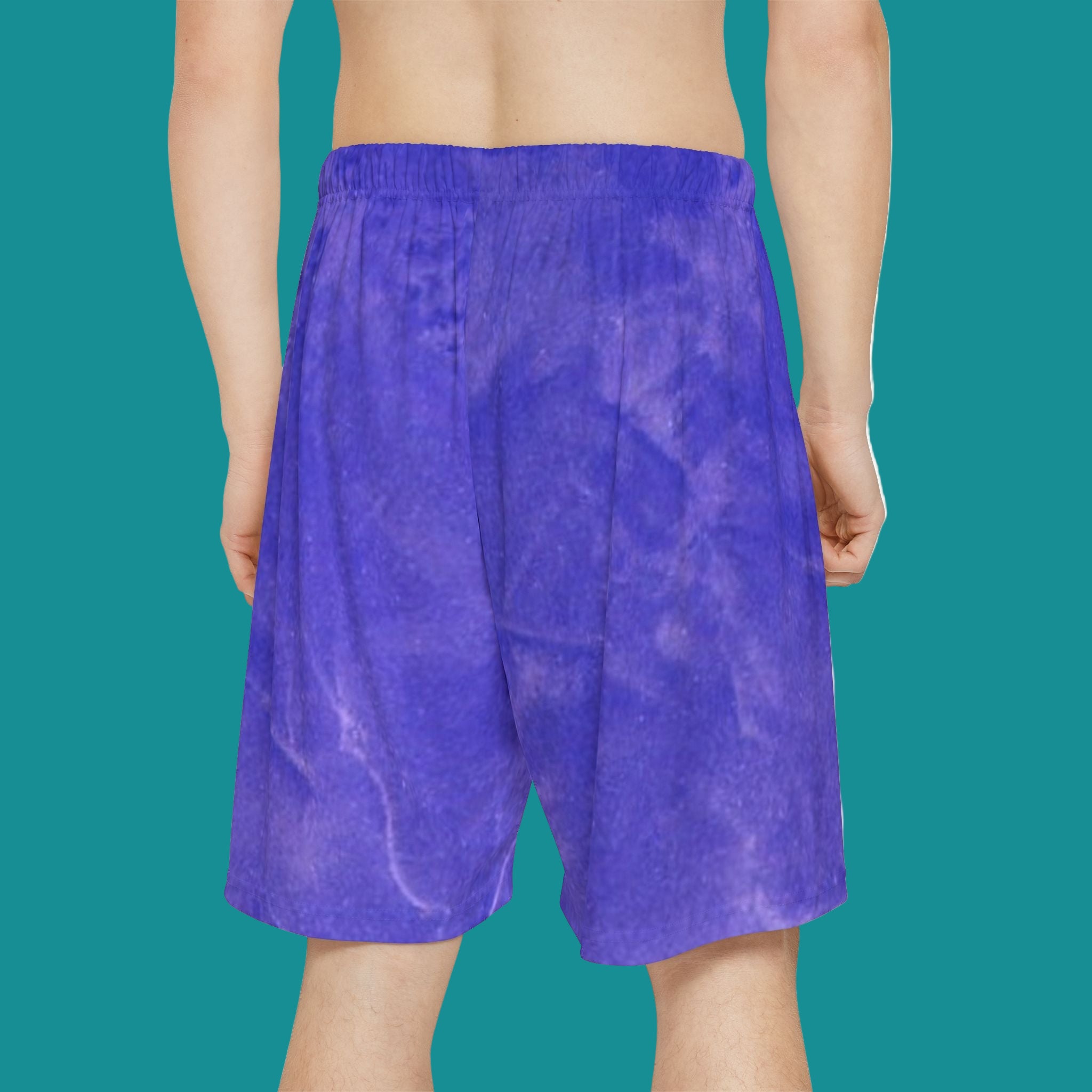 Blue abstract art shorts worn by a person on a teal background