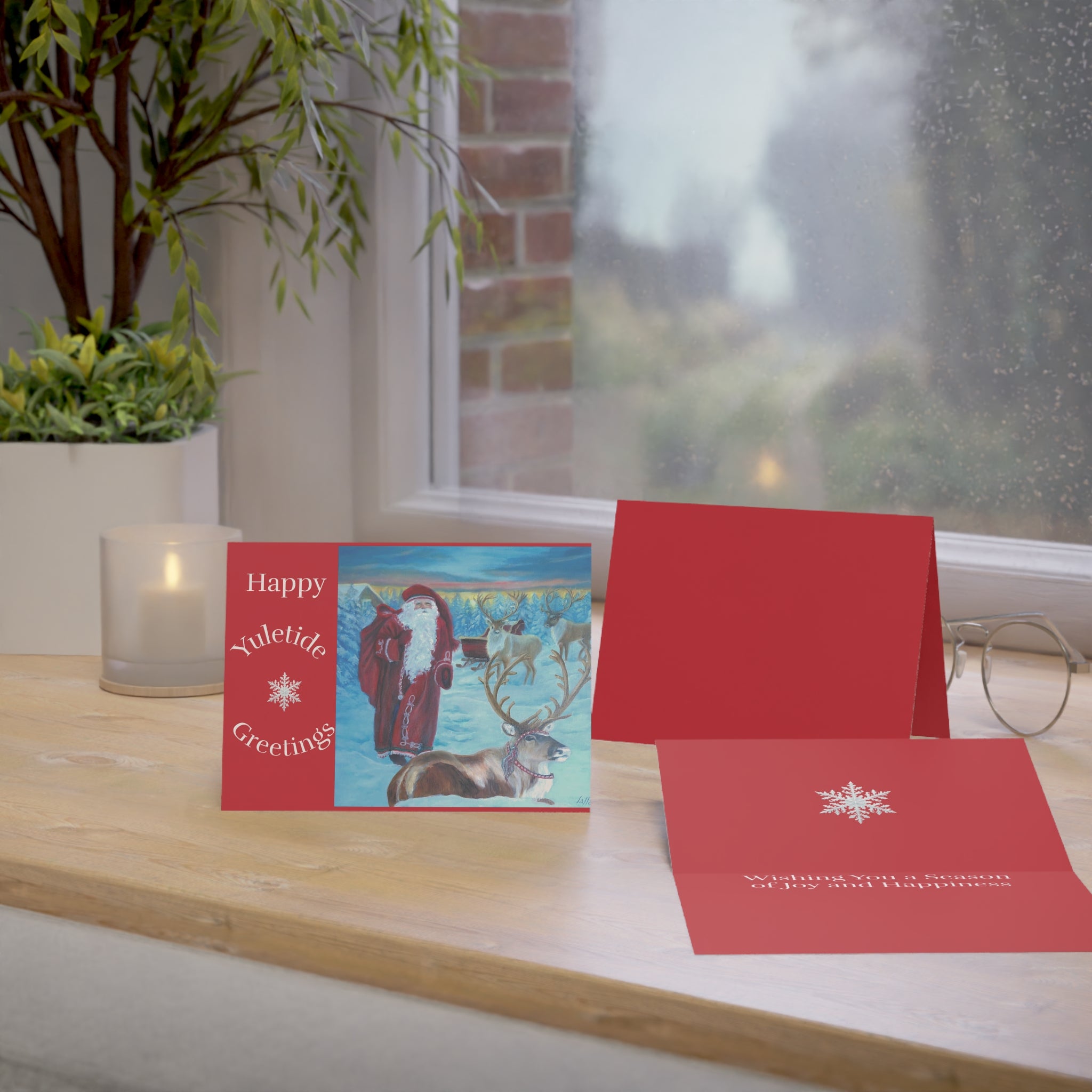 Red Christmas card with Santa Claus design on a wooden surface.