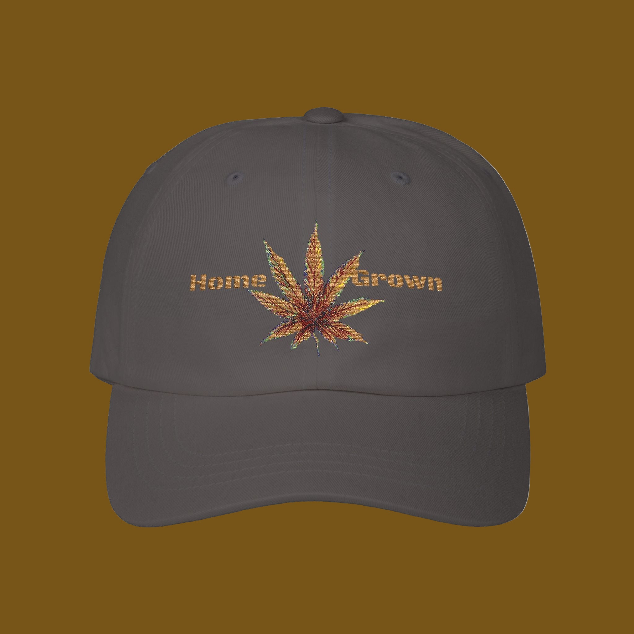 Dark gray cap with embroidered cannabis leaf and 'Home Grown' text on a brown background