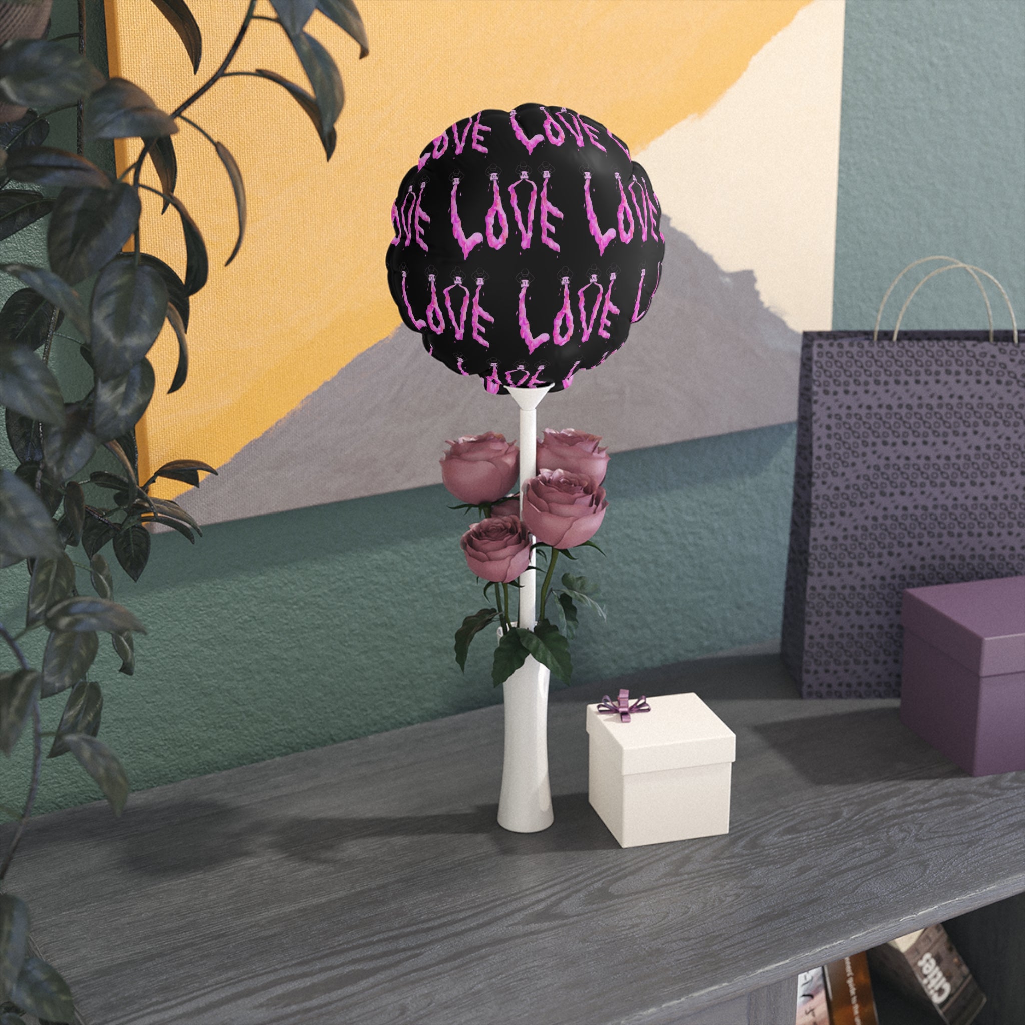 Decorative item with 'LOVE' text and flowers on a table against a colorful wall.