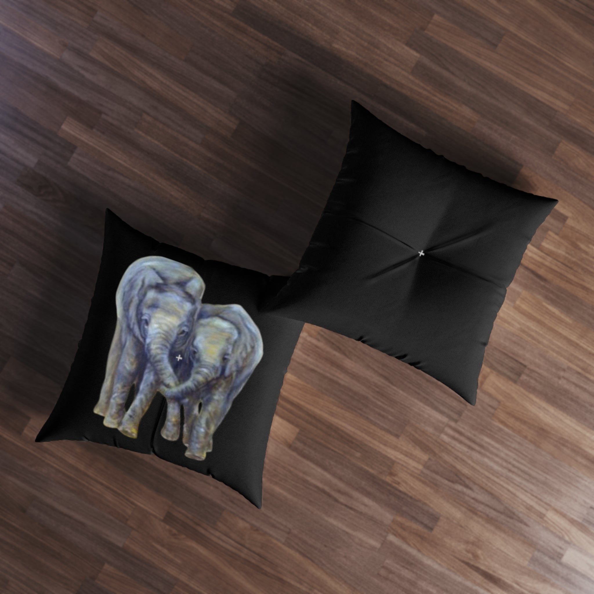 Black pillow with elephant design on a wooden floor