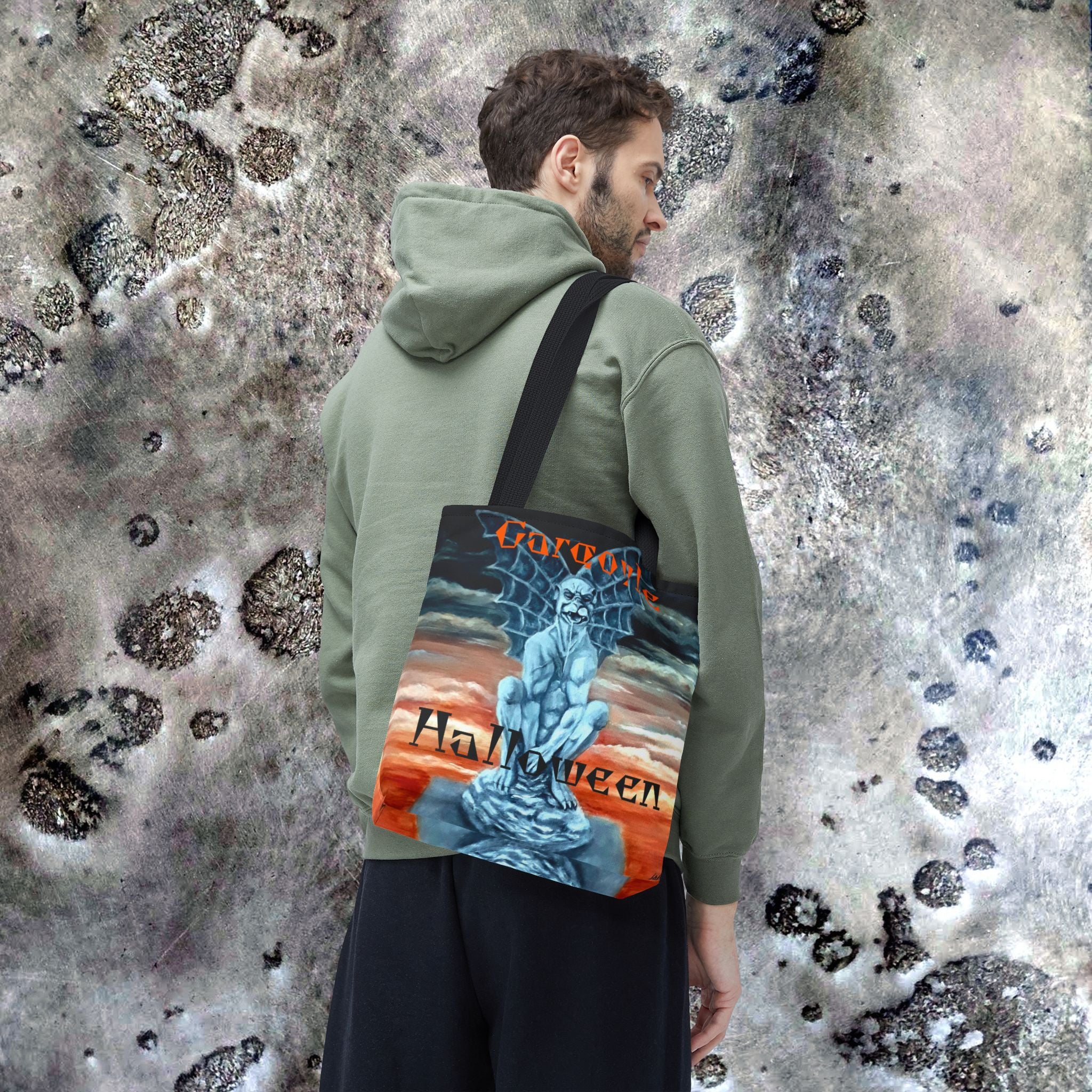 Person wearing a green hoodie with a 'Gorillaz Halloween' bag on a textured surface