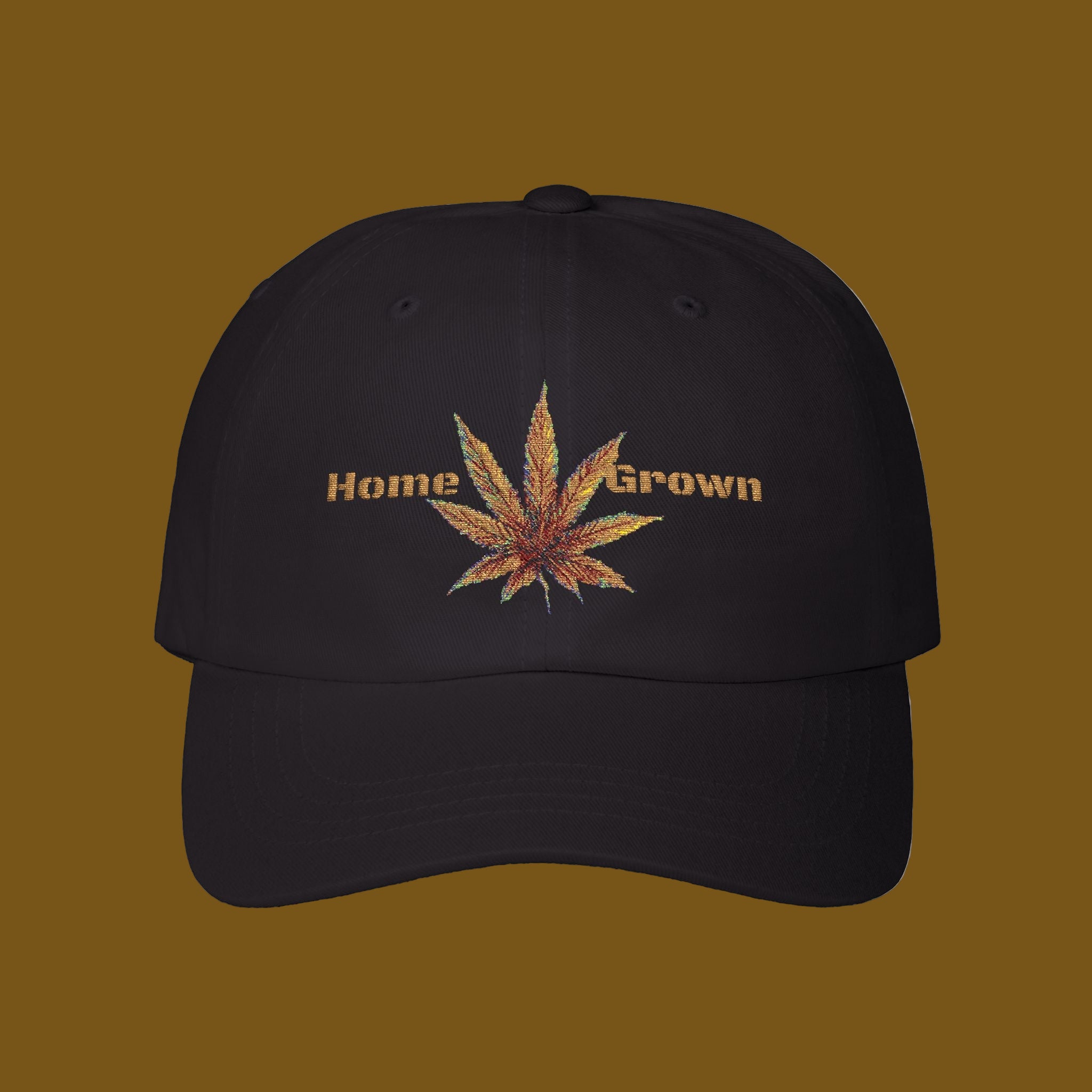 Black cap with embroidered cannabis leaf and 'Home Grown' text on a brown background