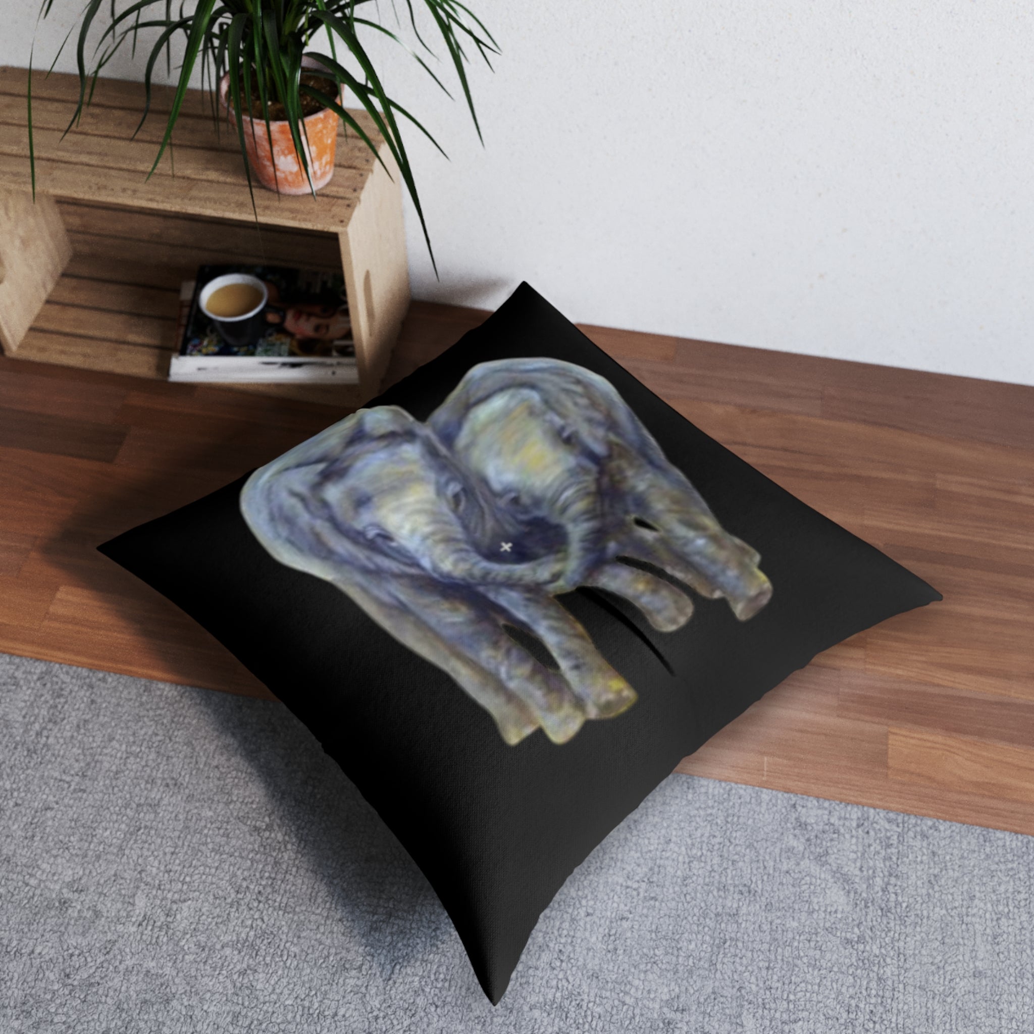 Decorative floor pillow with an elephant design on a wooden floor.