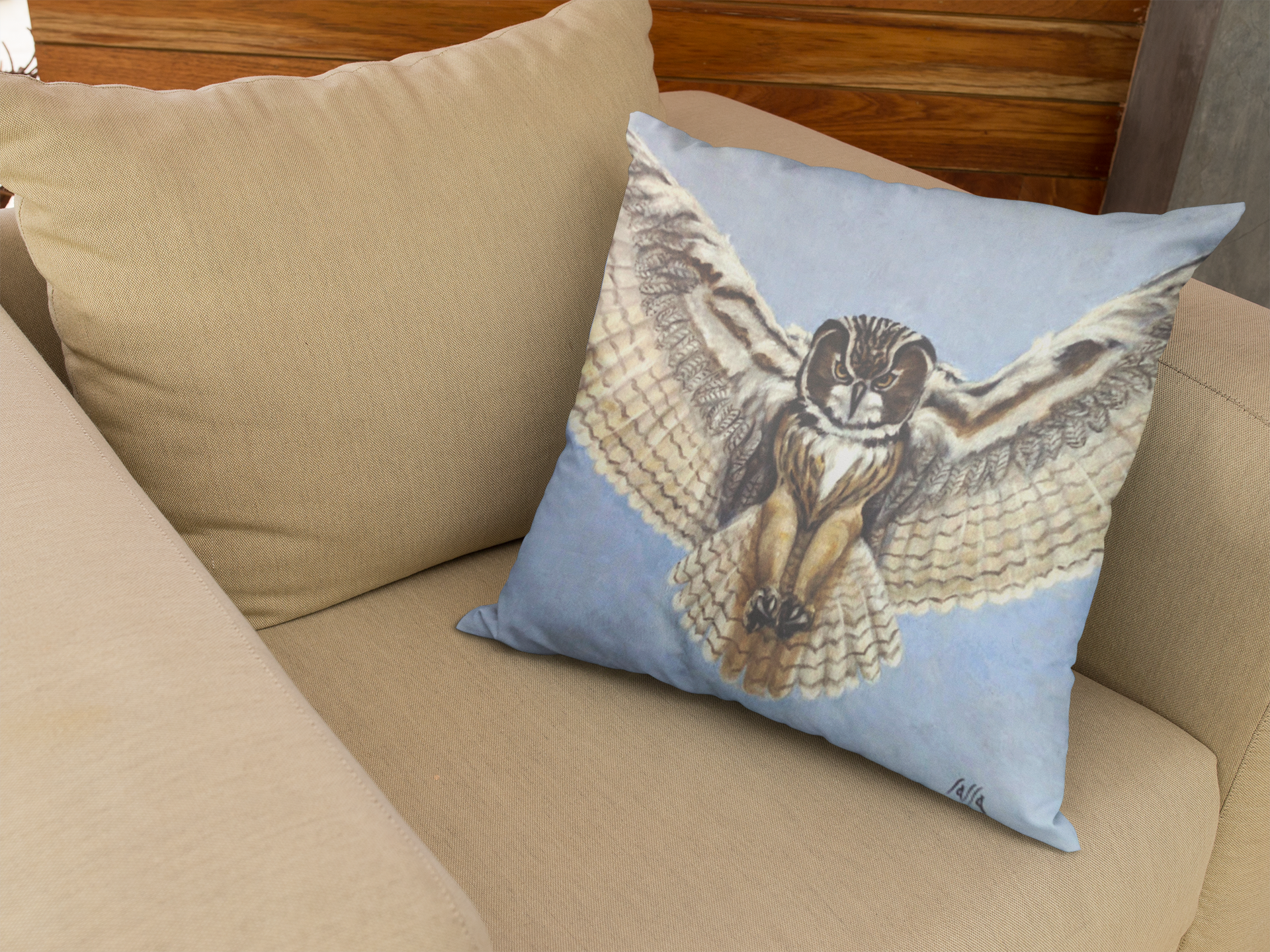 Decorative pillow with an owl design on a beige couch