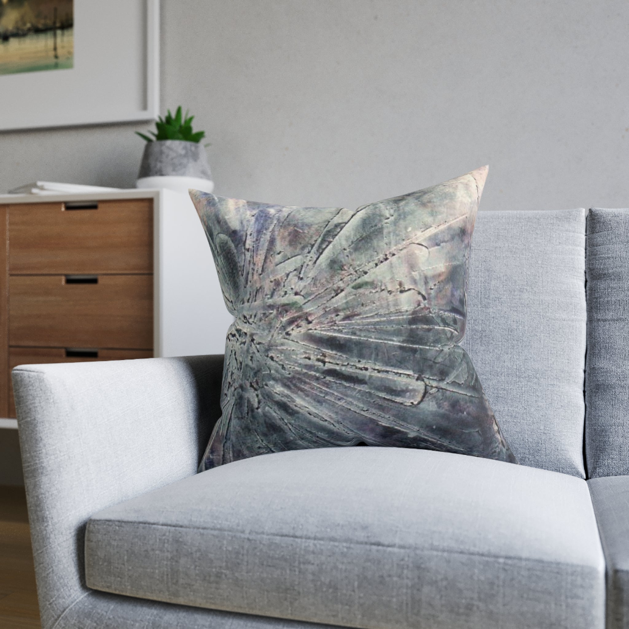 Decorative pillow on a gray chair in a living room setting
