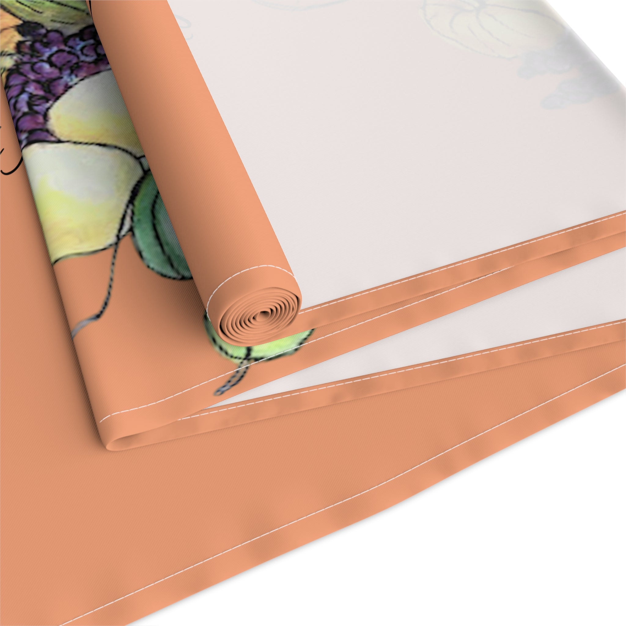 Roll of orange table runner with a cornucopia design on a white background