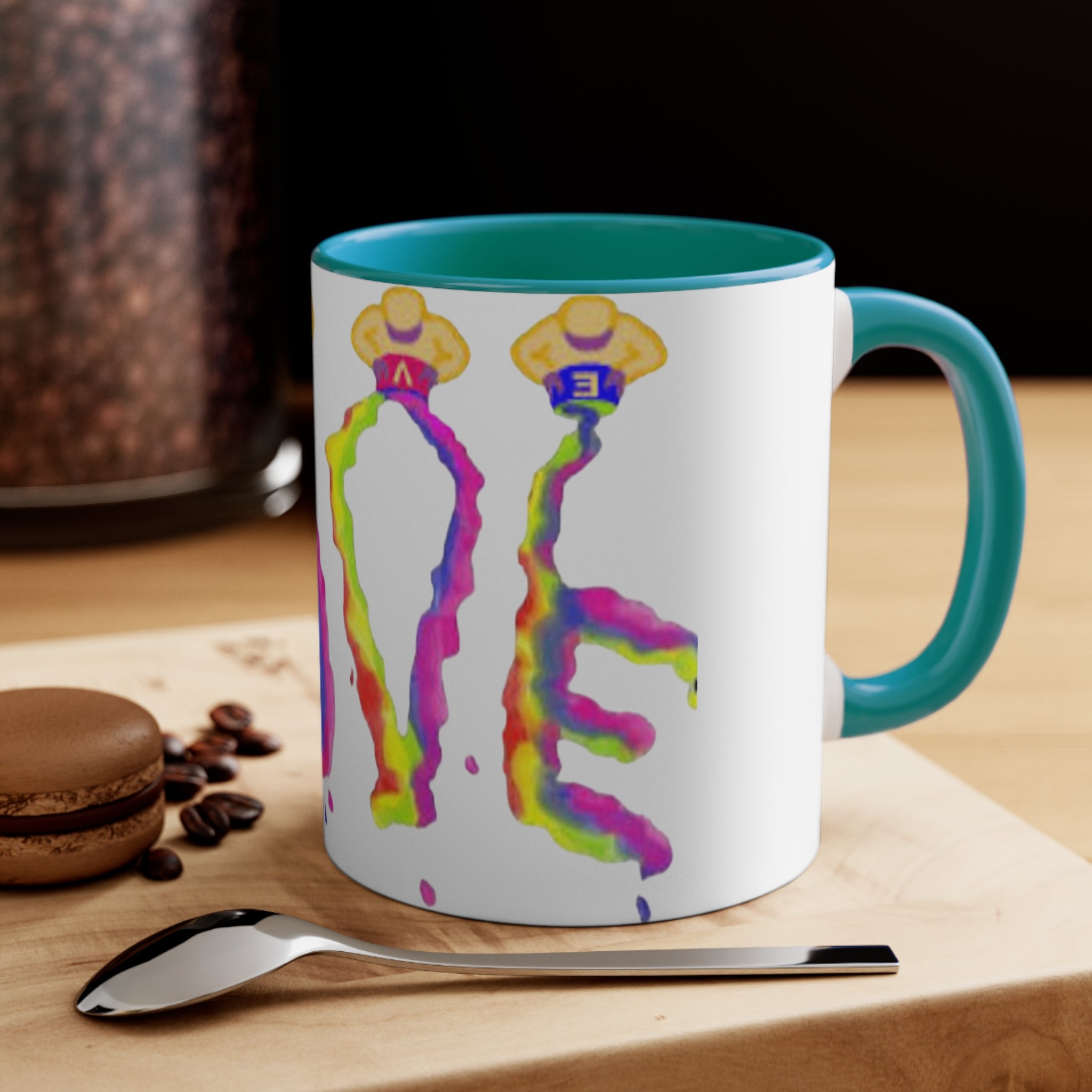 Mug with colorful design on a wooden surface with coffee beans and a spoon.