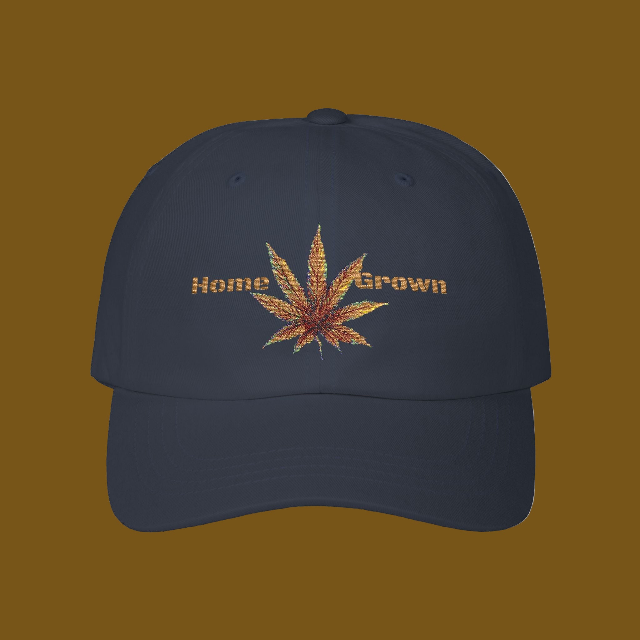 Navy blue cap with embroidered cannabis leaf and 'Home Grown' text on a brown background