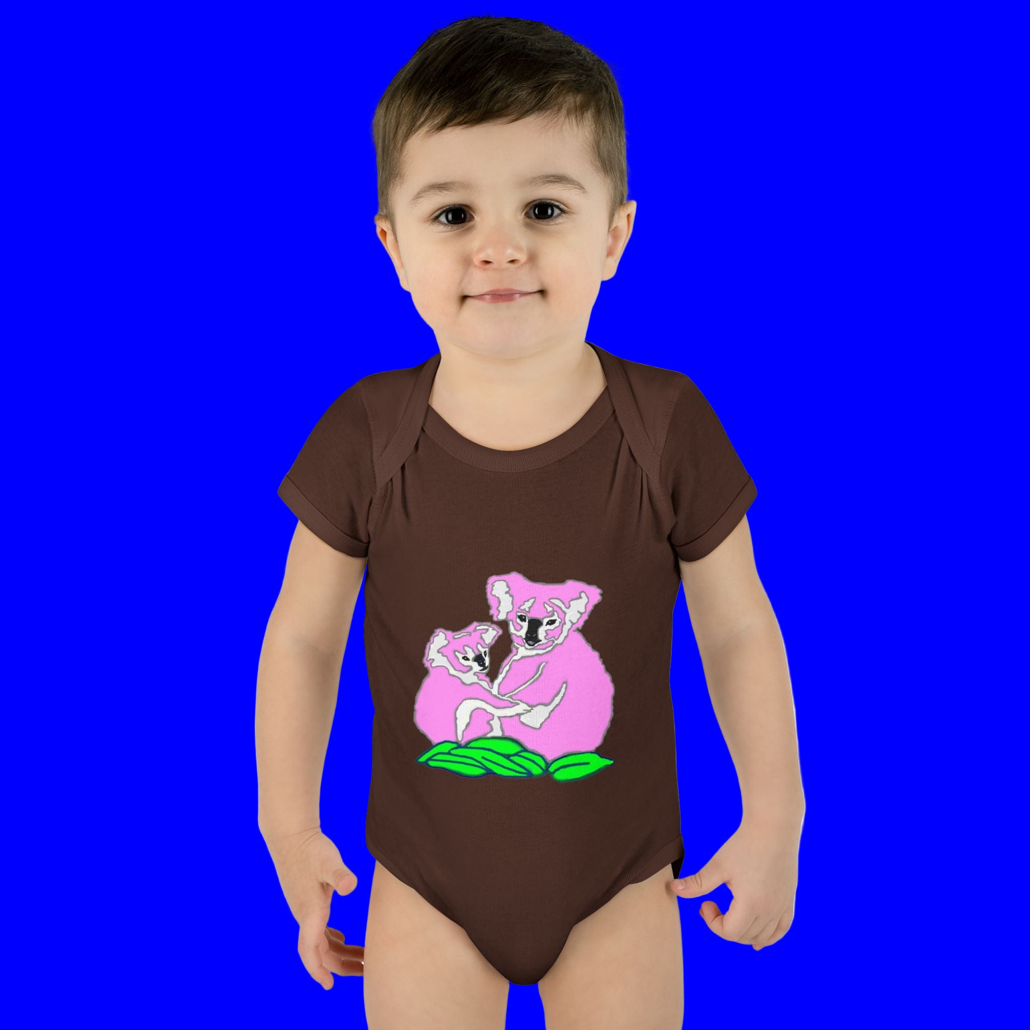 Child wearing a brown onesie with pink koala design on a white background