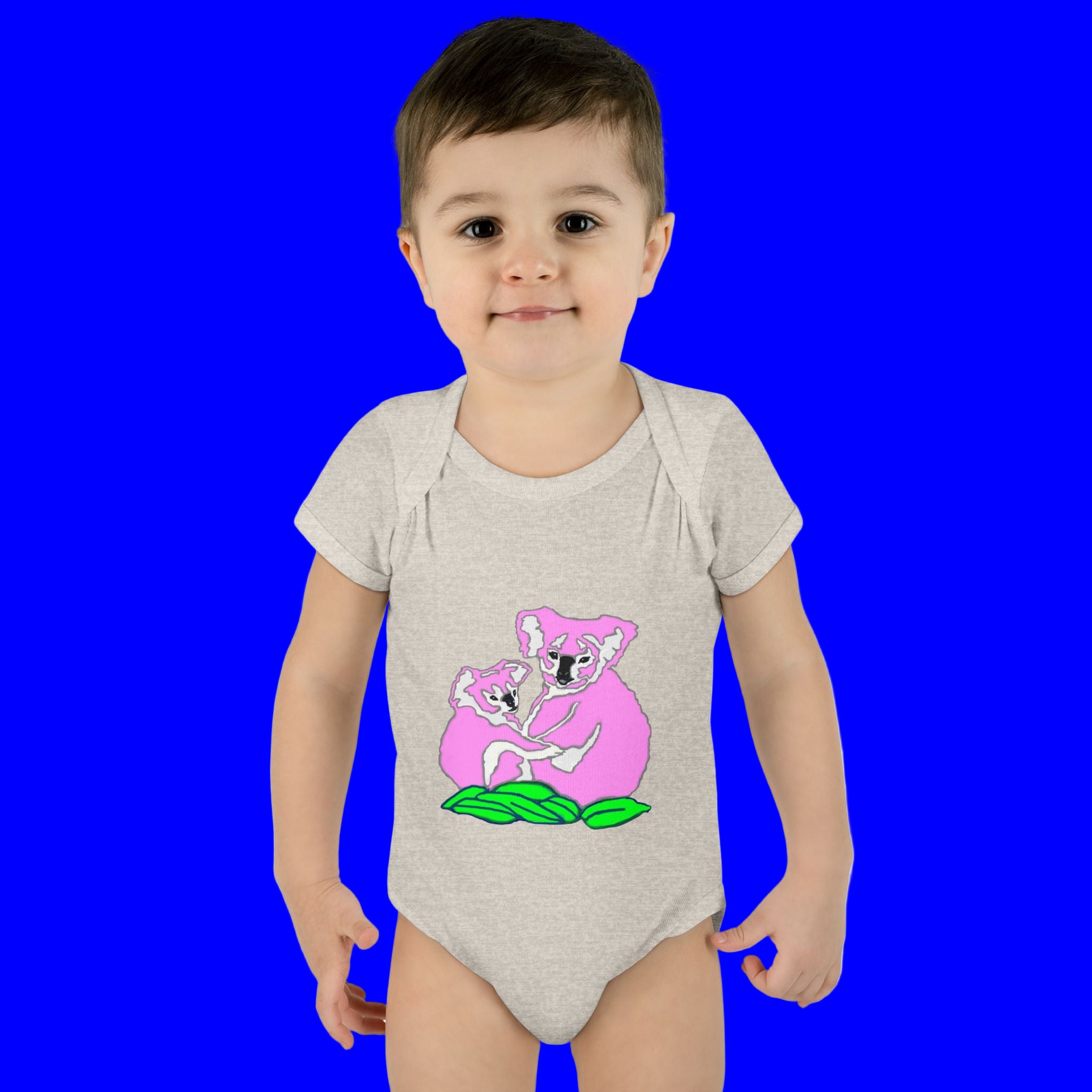 Child wearing a gray onesie with a pink koala design on a white background