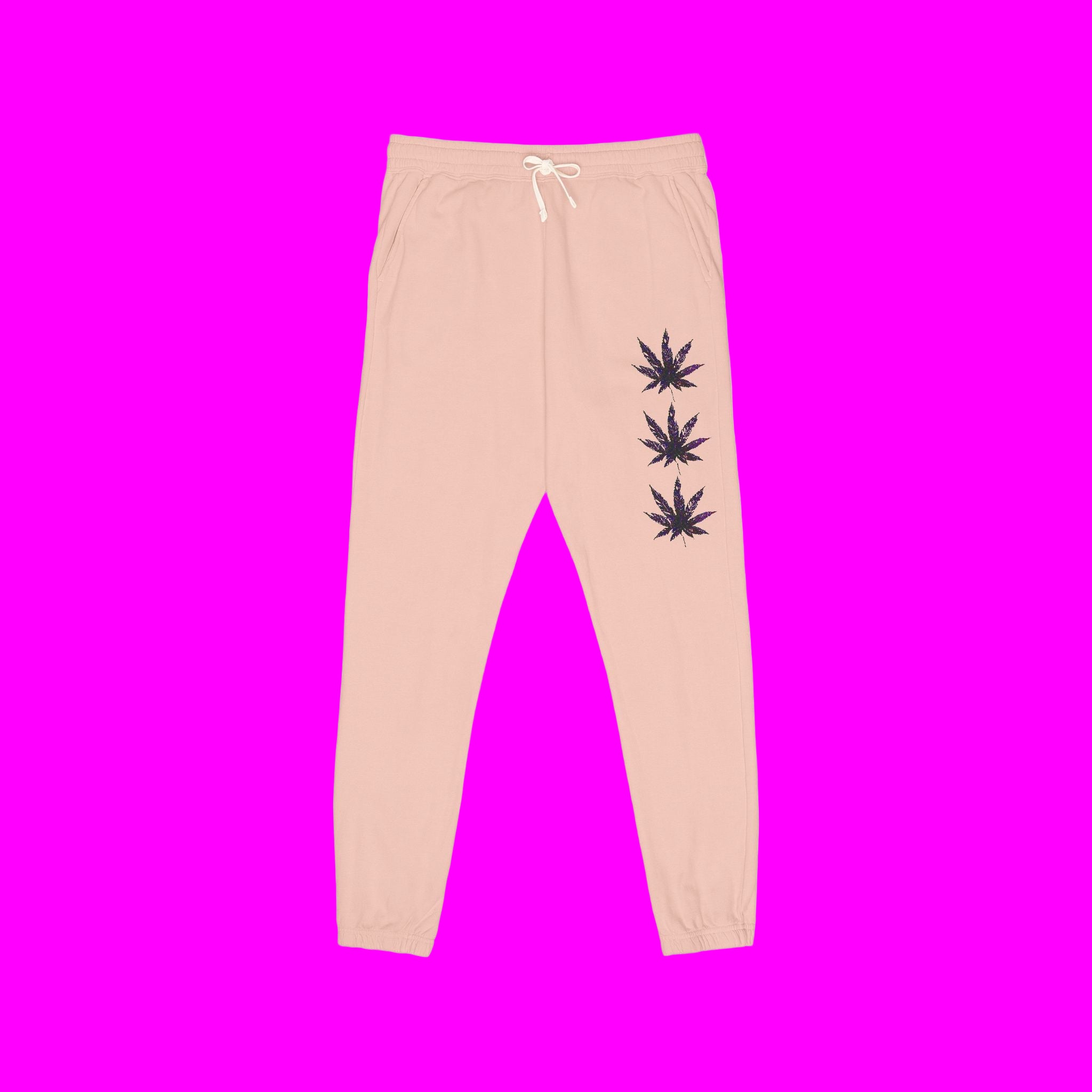 Pink sweatpants with black leaf designs on a pink background
