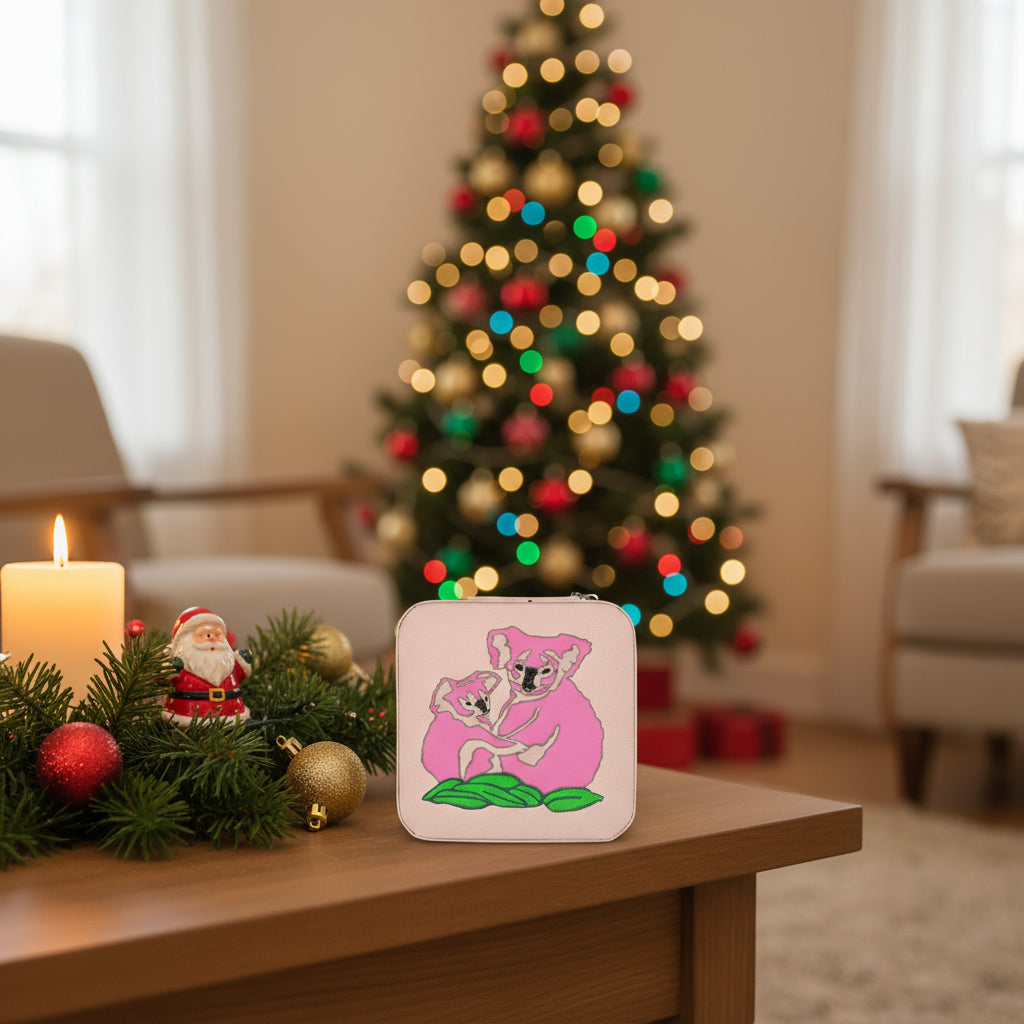 Pink pouch with embroidered koala design on a green background