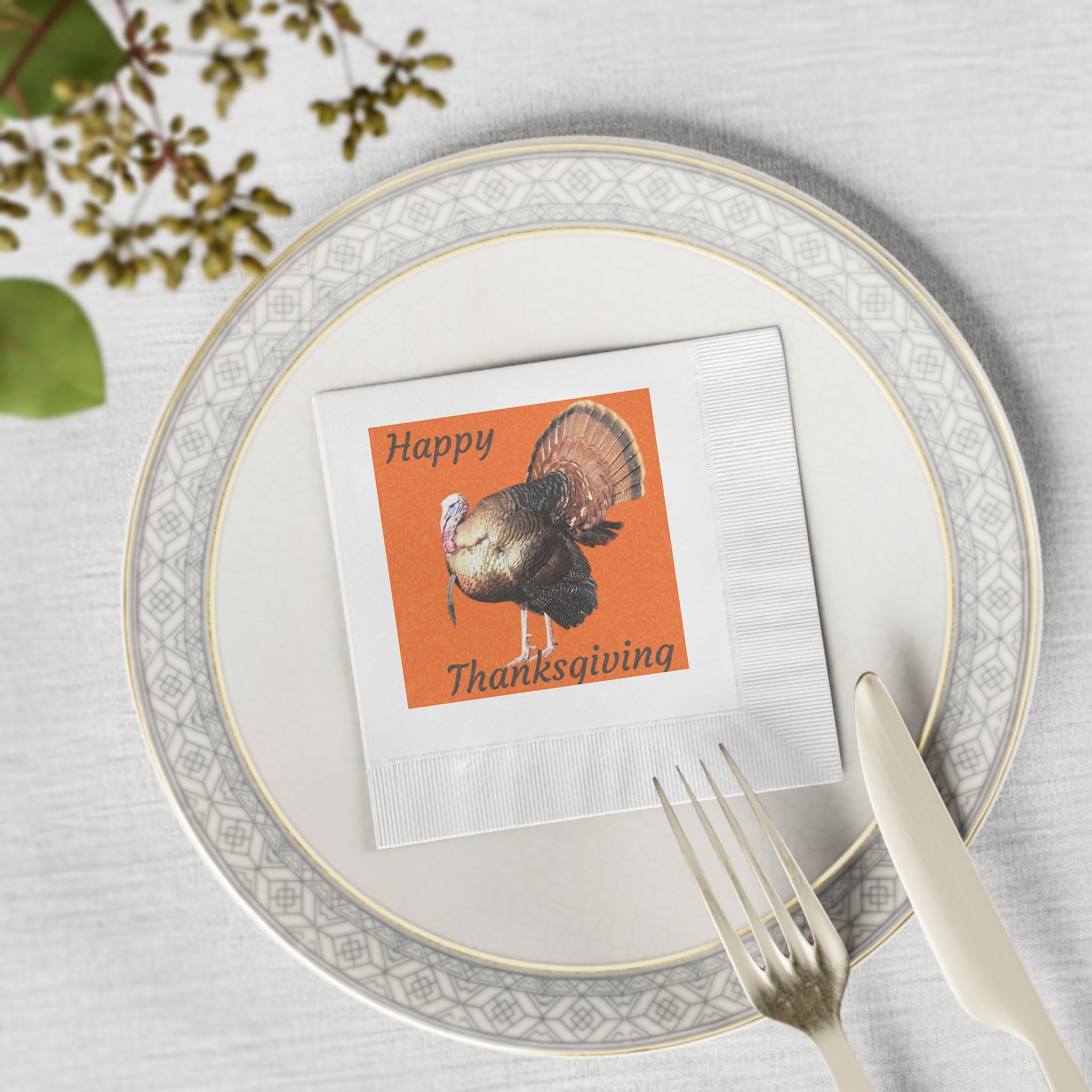 Place setting with a 'Happy Thanksgiving' card featuring a turkey on a decorative plate.