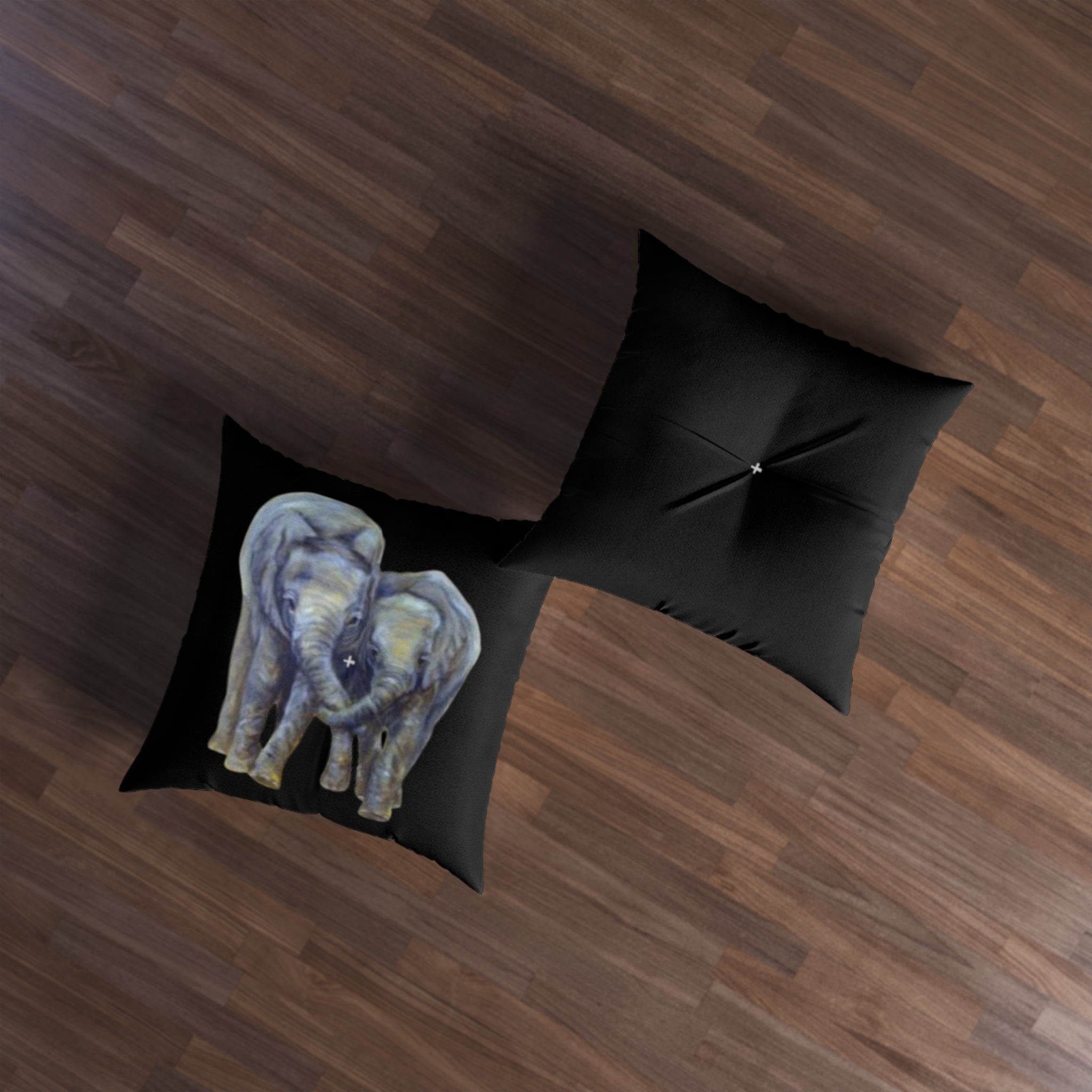 Black pillow with elephant design on a wooden floor