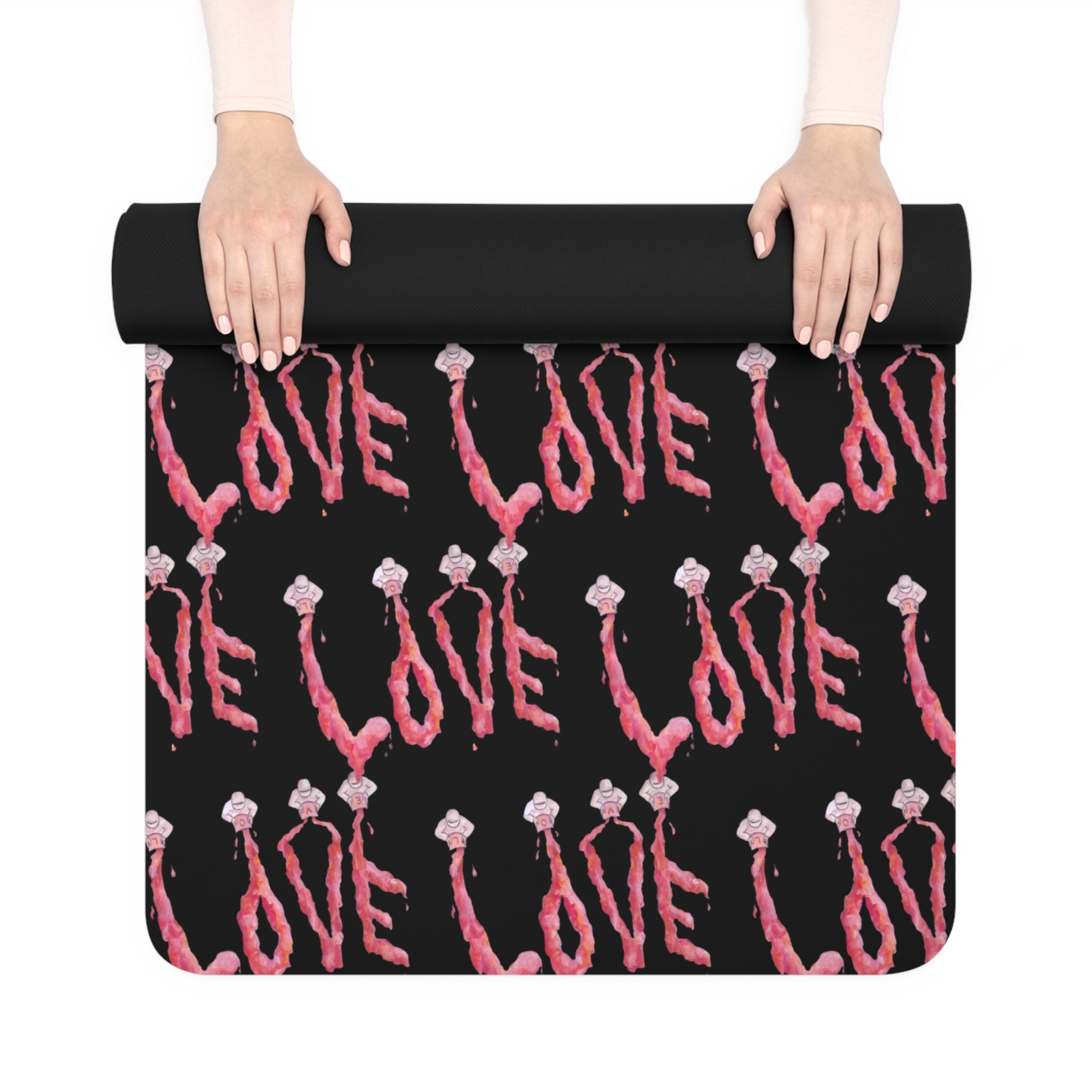 Black yoga mat with pink 'LOVE' text and skeleton hand design held by a person.