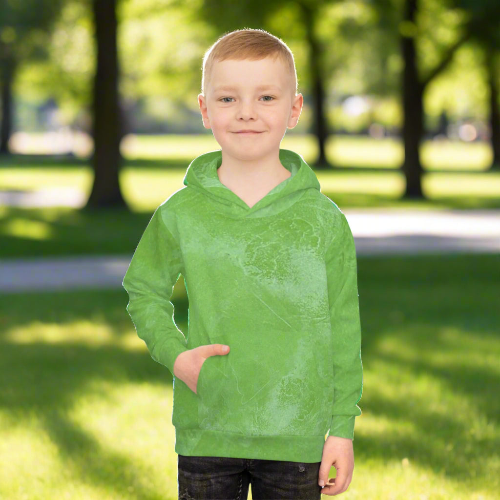 Child wearing a green hoodie in a a sunny park