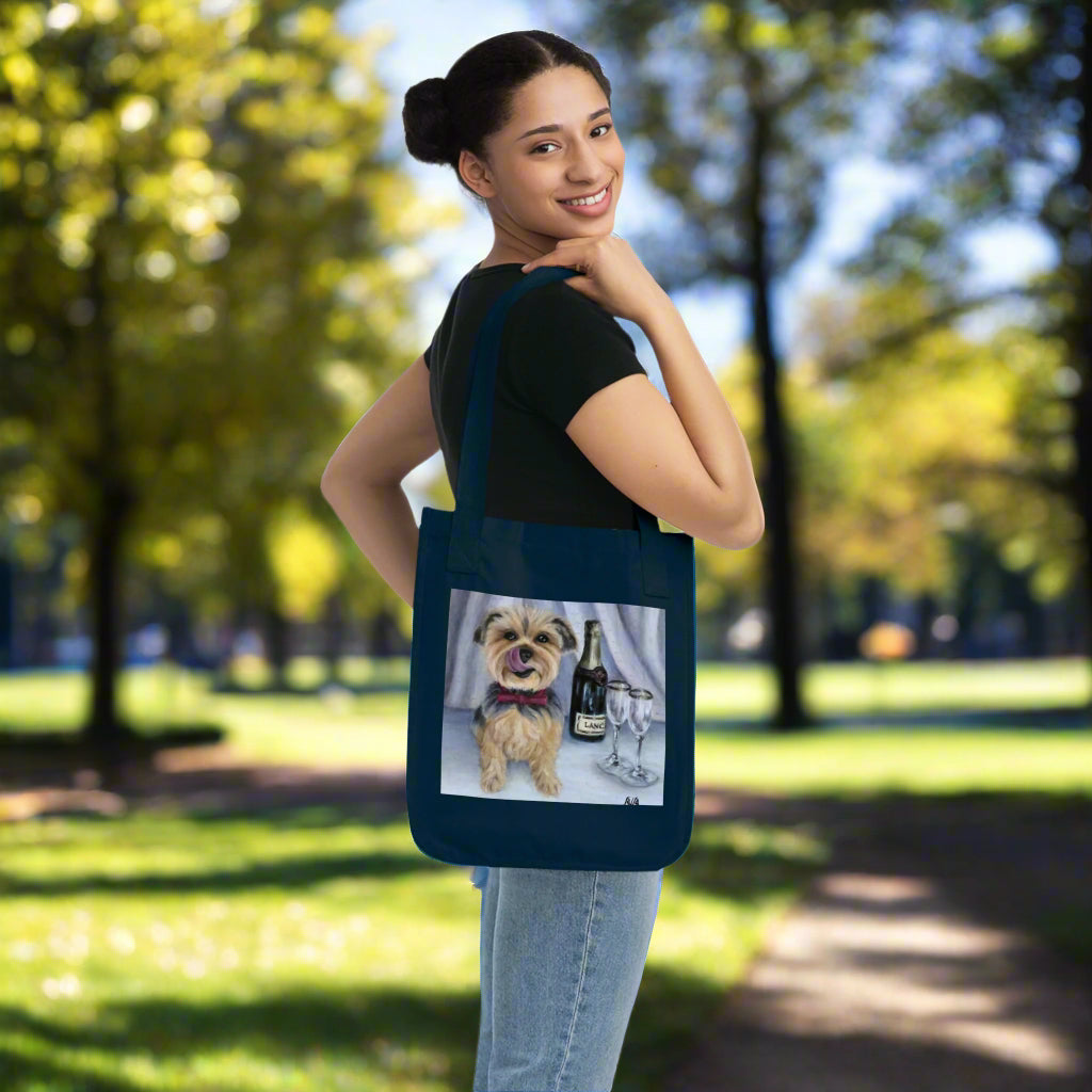 Woman holding a navy blue tote bag with a dog and wine design on a white background