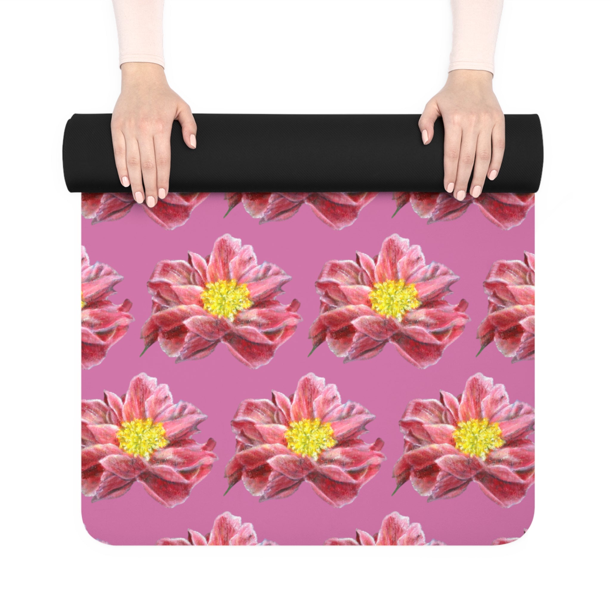 Yoga mat with pink flower pattern held by a person on a white background