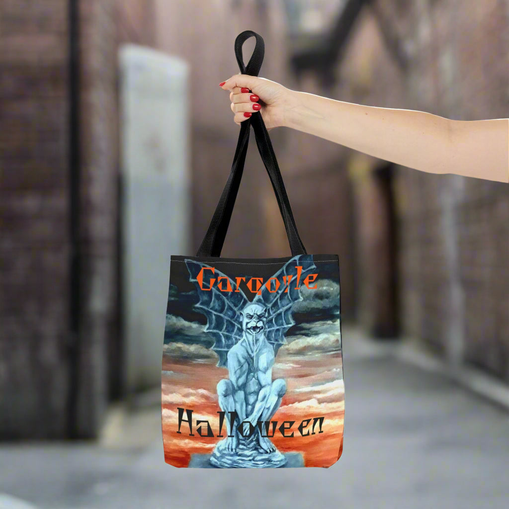 Tote bag with 'Gargoyle Halloween' design held by a hand in a scary alleyway