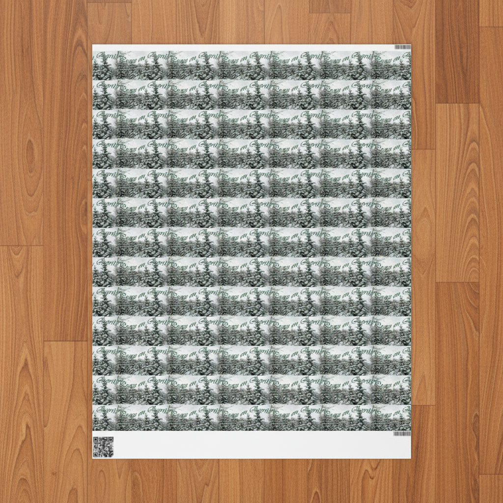 Snowy Pines with text wrapping paper for the holidays on a wood floor